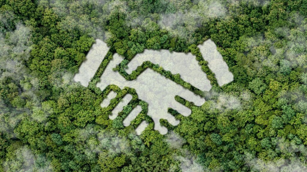 Handschlag-Design in einem Wald symbolisiert Partnerschaften für nachhaltige Entwicklung