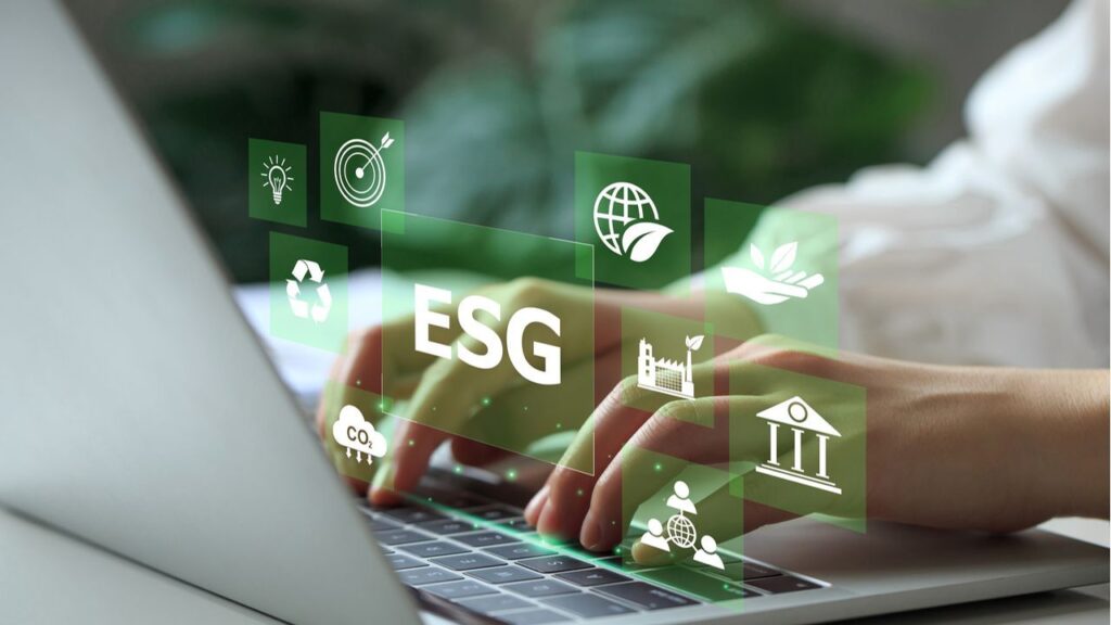 Person verwendet Laptop mit ESG-Investitionsstrategie-Symbolen auf dem Bildschirm im Grünen